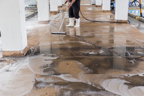 asian-worker-cleaning-sand-wash-exterior-walkway